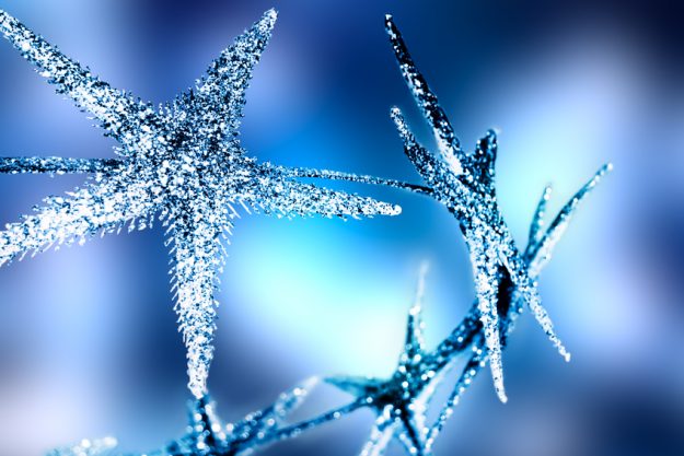 Christmas sparkling stars on blue background.