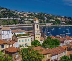 Brown and white concrete buildings near body of water under blue